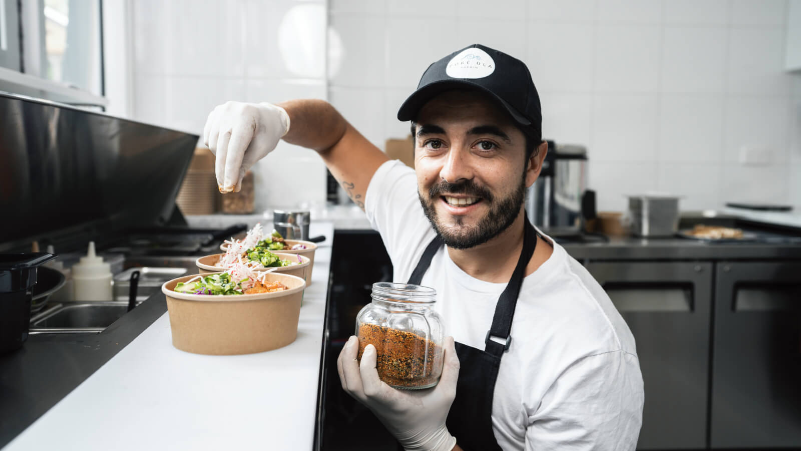 Poké Ola cook seasoning poke bowl in Darwin